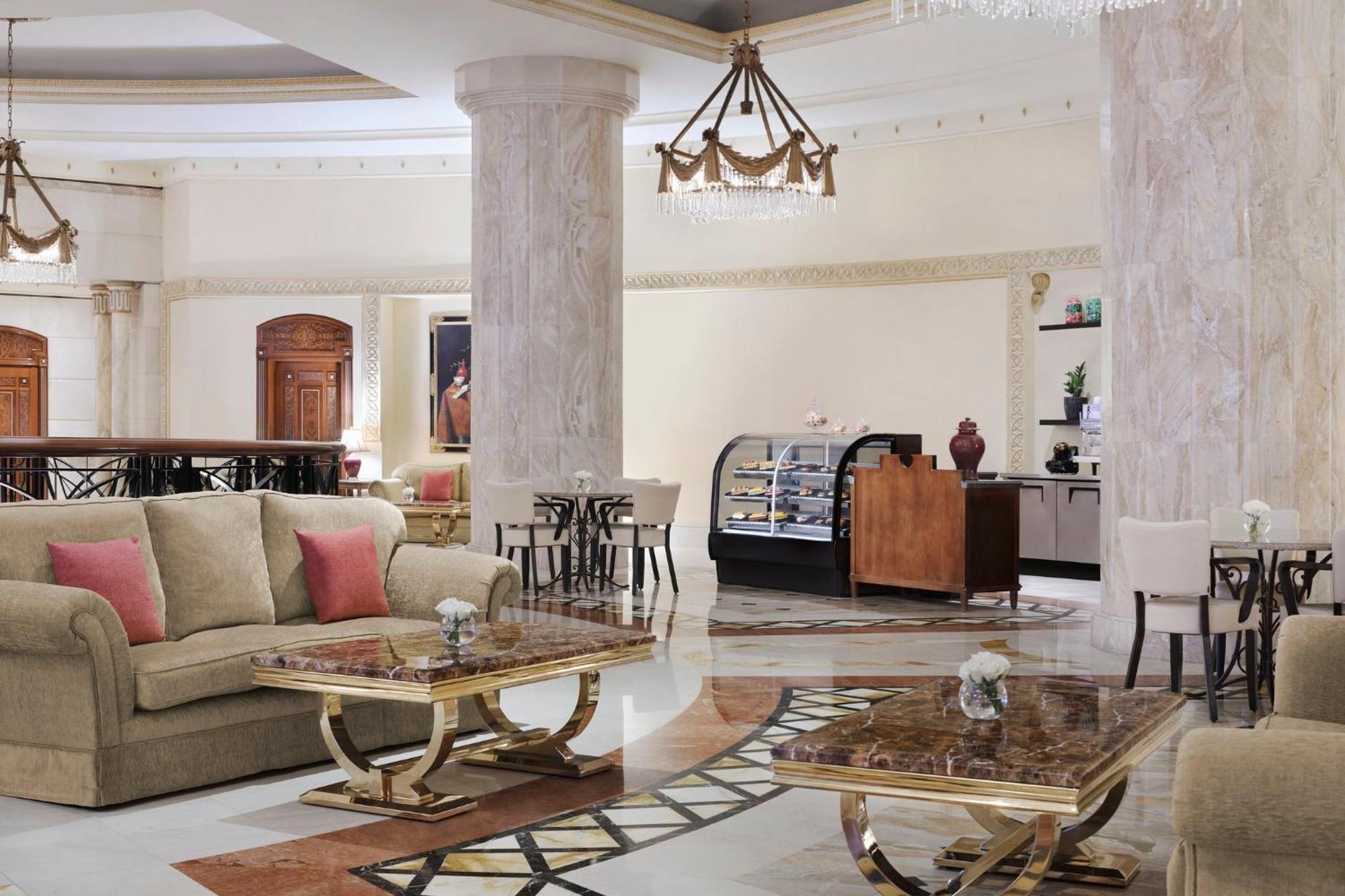Intercontinental Dar Al Iman Madinah By Ihg Hotel Medina Kültér fotó The image shows a spacious and elegantly designed hotel lobby or lounge area. It features plush sofas with cushions, stylish coffee tables, and decorative elements. The decor includes marble columns and a chandelier hanging from the ceiling, adding t